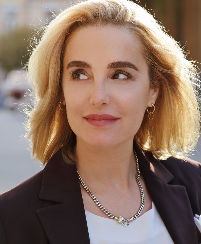 Woman with blonde hair and a stylish outfit.